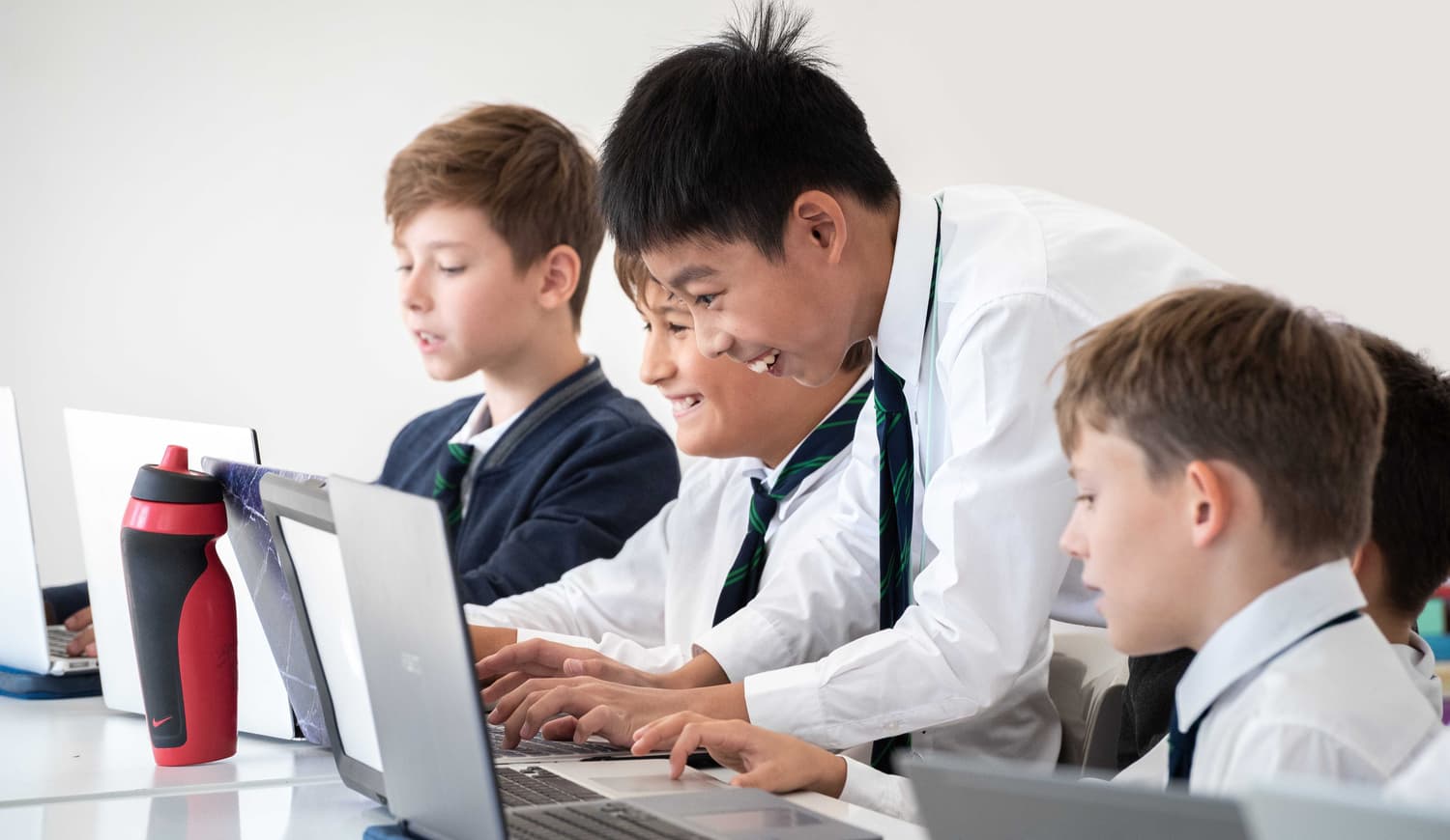 Students working with computers and smiling