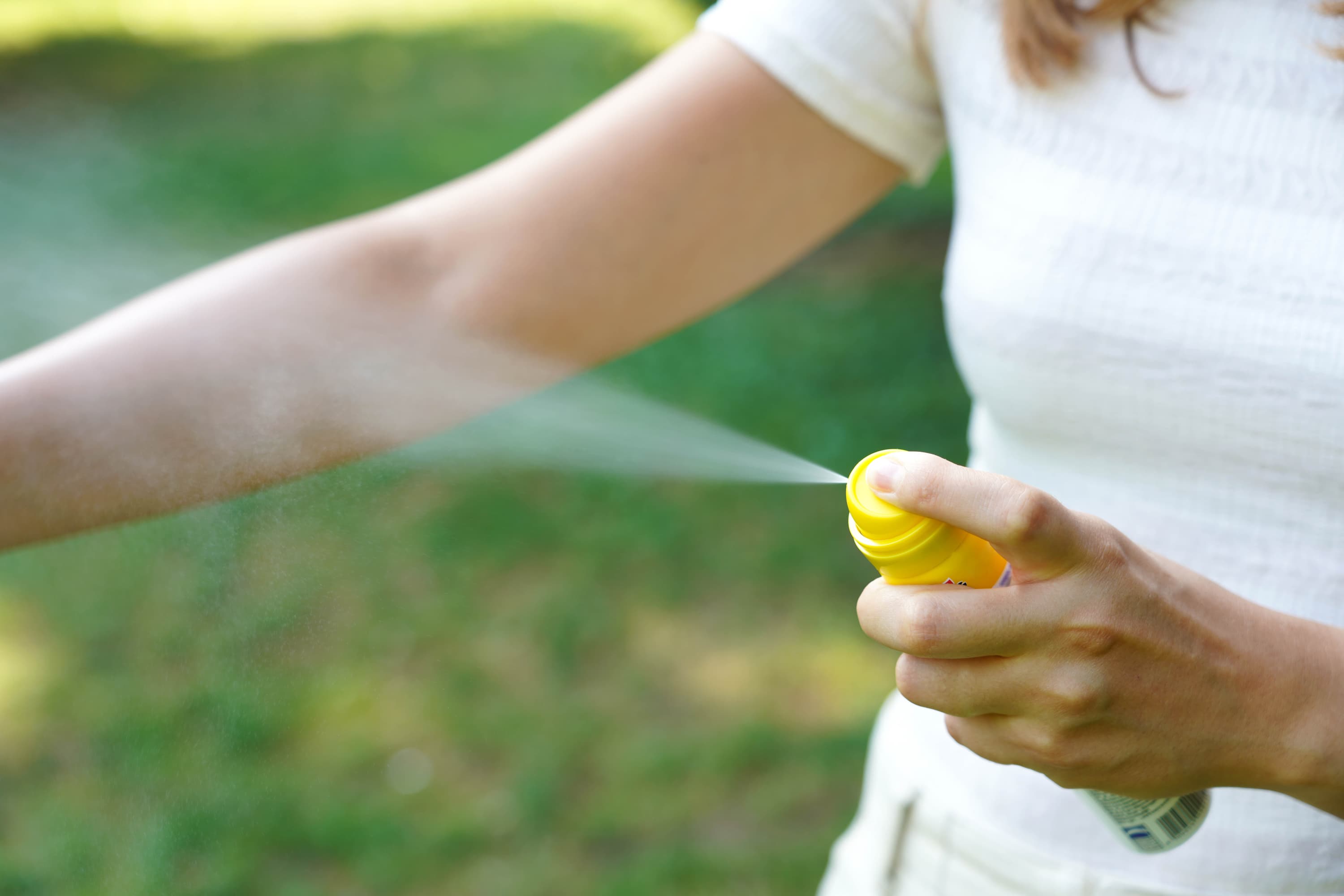 Young woman applying mosquito repellent her arm during hike nature insect repellent skin protection against tick other insect focus top spray container