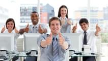 Lively business people with thumbs up in the office