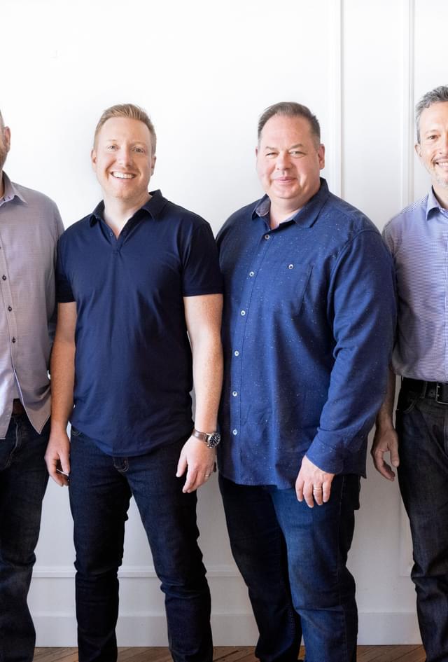 picture of the four founders of Dig Insights. They are four white males standing against a white background, smiling at the camera.
