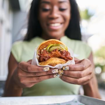 Woman holding a chicken burger