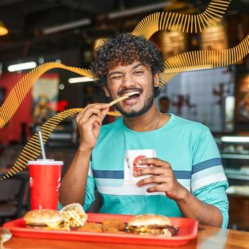 Man happily eating fries at restaurant.