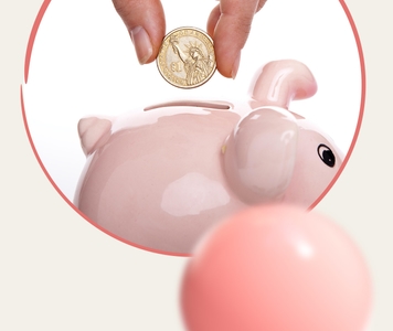 Hand putting a coin into a piggybank
