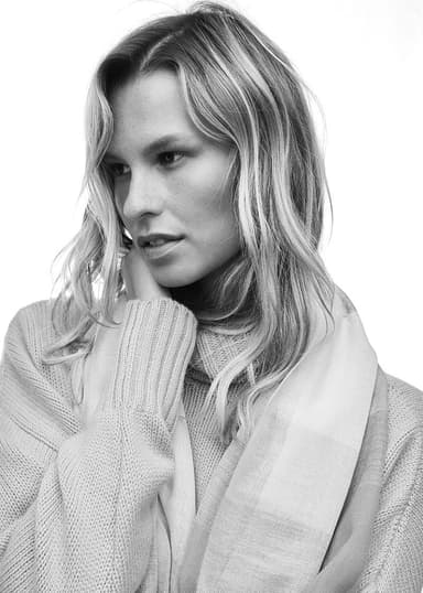 Model wearing a Johnstons of Elgin Lightweight Scarf draped around her neck shot in black and white