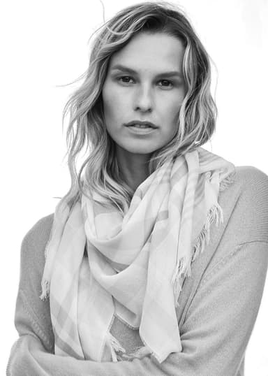 Model wearing a Johnstons of Elgin lightweight scarf worn around her neck shot in black and white