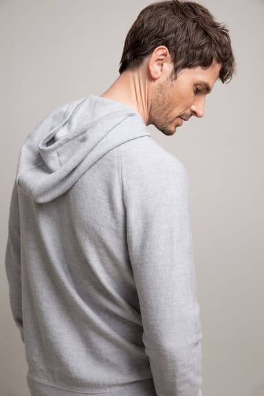 Johnstons of Elgin's Grey Mix Seamless Merino Hoodie on model on a grey background