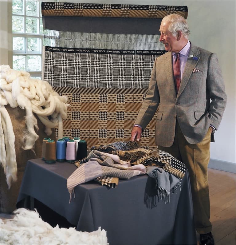 King Charles III visiting Johnstons of Elgin on looking at the Campaign for Wool 10th Anniversary Scarf collaboration with Mother of Pearl
