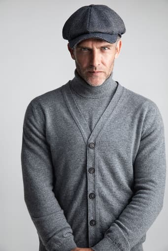 Johnstons of Elgin's Granite V Neck Cashmere Cardigan on model wearing Granite Cashmere roll neck jumper with grey cap