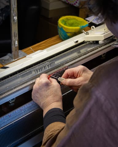 Maureen White, Hand Knitting Artisan X  Johnstons of Elgin working on her hand knitting machine. Proceeds go to the Longhope Lifeboat service.