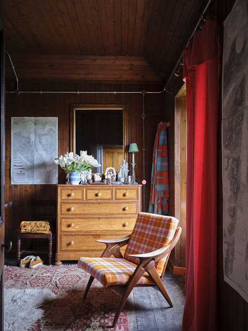 Wooden Chair with Ben Pentreath and Johnstons of Elgin fabric covered on cushions in room at Ben Pentreath’s bothy in Argyll