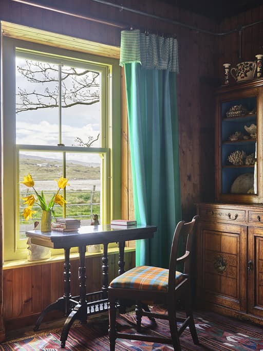 Ben Pentreath and Johnstons of Elgin's fabric on cushion of wooden chair in Ben Pentreath’s bothy in Argyll