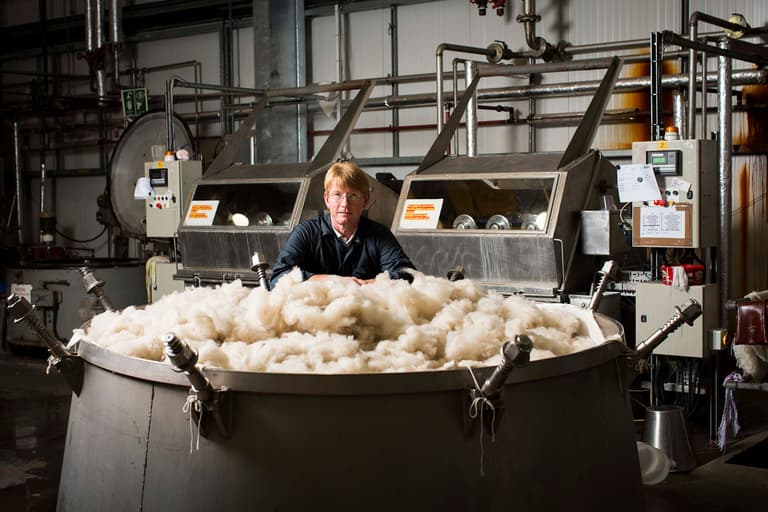 Johnstons of Elgin raw cashmere fibres in the dye vat with a Johnstons of Elgin employee watching over