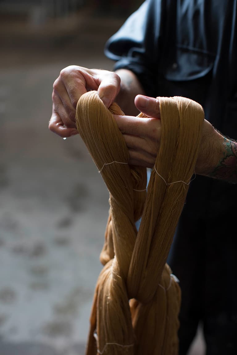 Johnstons of Elgin dyed cashmere yarn being held by one of our employees in the dye house