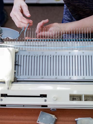Johnstons of Elgin hand knitting machine with hands working