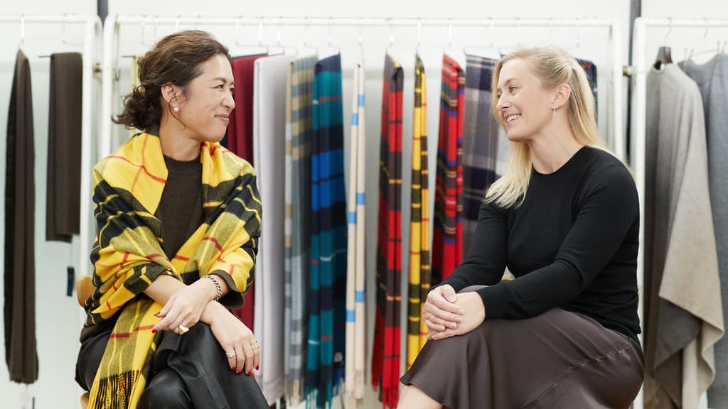 Johnstons of Elgin's Design Director for Wovens, Laura Garner with influential Stylist Naoko Okusa with cashmere stoles hanging in the background