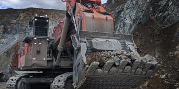 A giant industrial excavator truck carrying rocks
