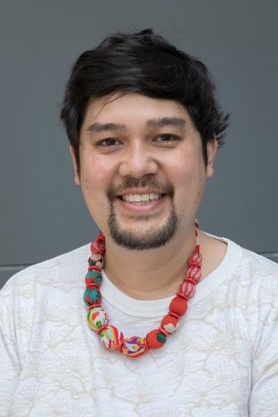 Shige sakurai headshot wearing a light shirt and colorful bead neckless