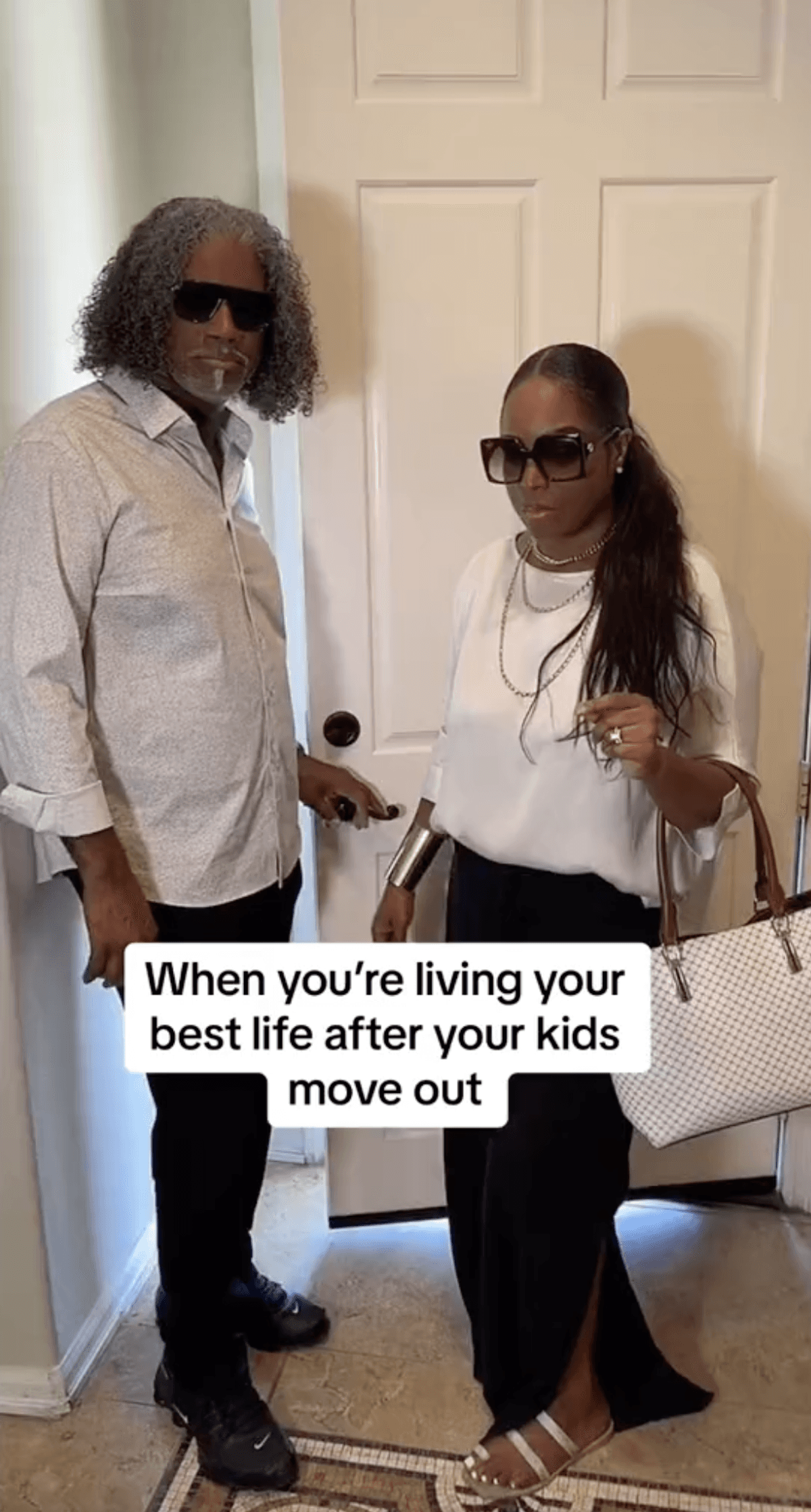 Two dressed up people wearing sunglasses standing next to a door and text that reads "When you're living your best life after your kids move out".