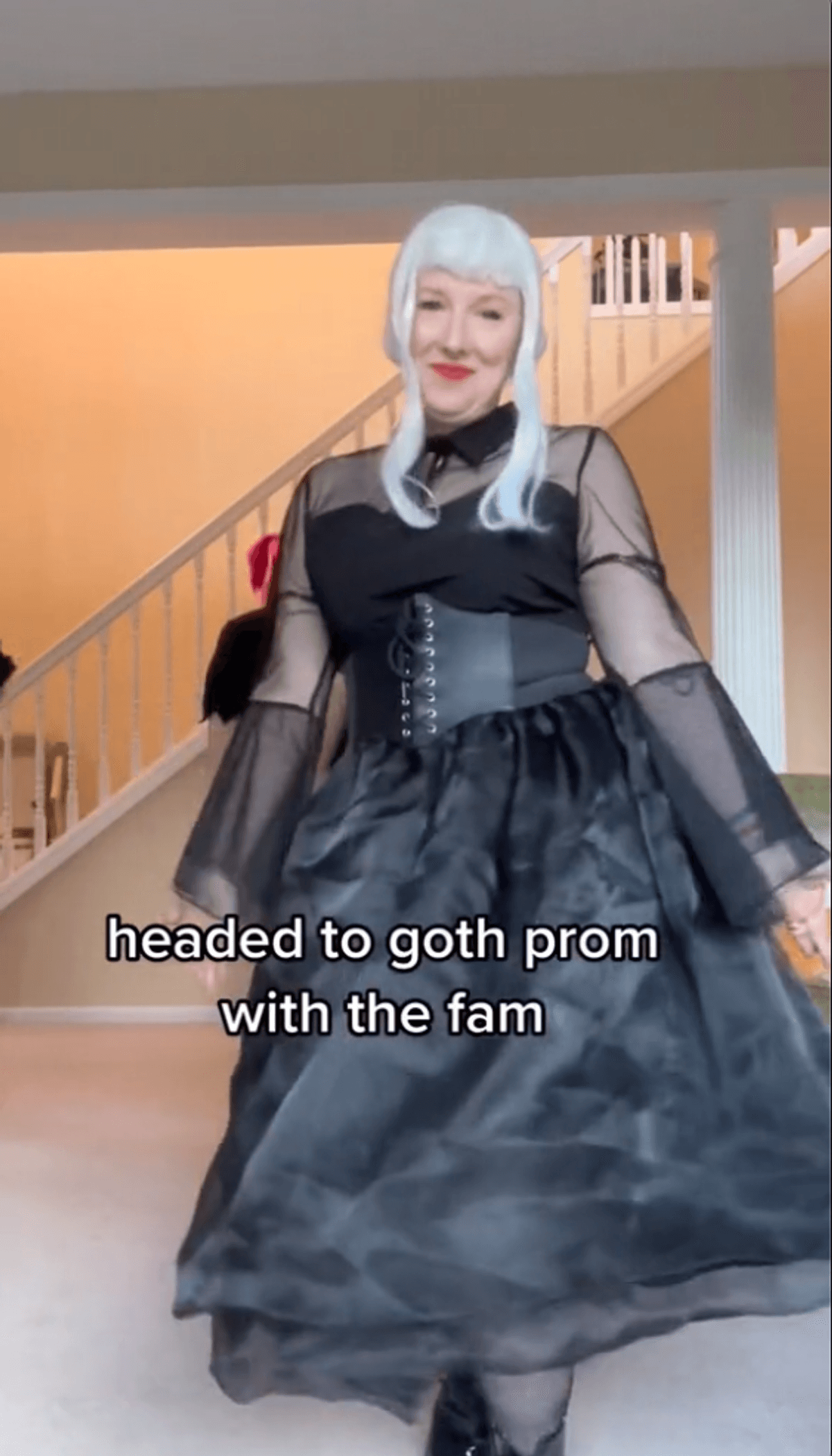 Person wearing a black dress with text that reads "headed to goth prom with the fam".