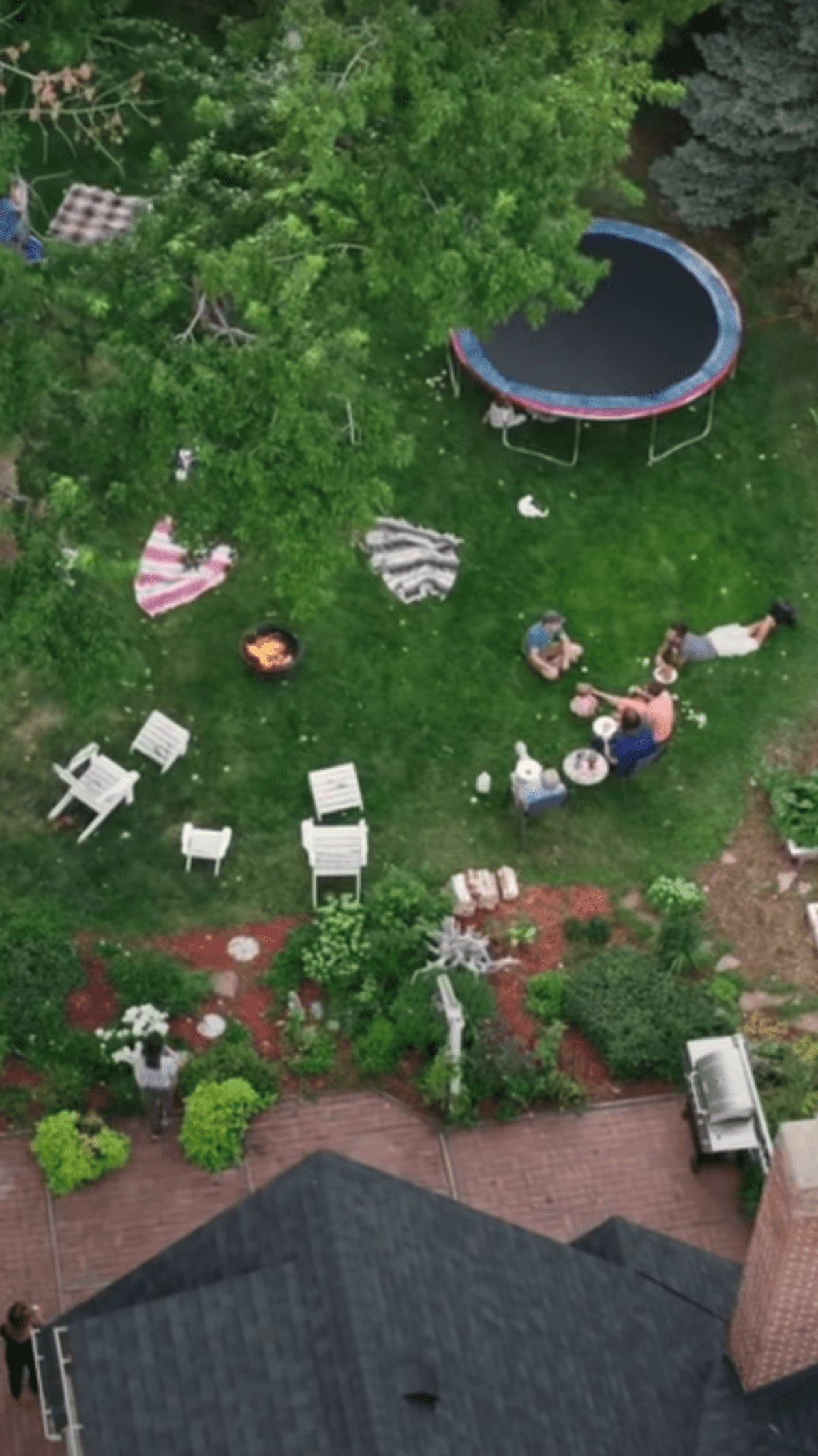 Aerial view of a house's backyard with people sitting.