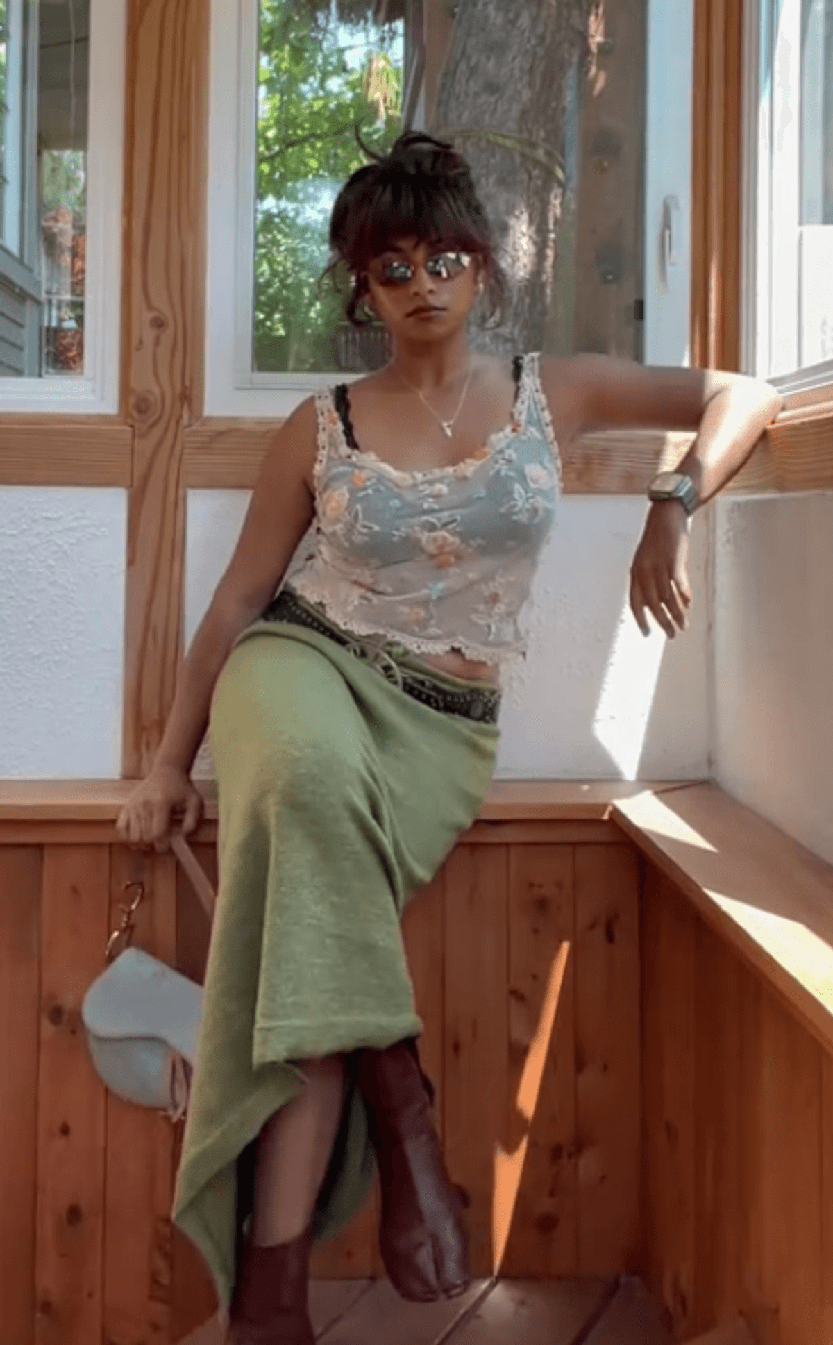 Person sitting by window wearing vintage clothes.