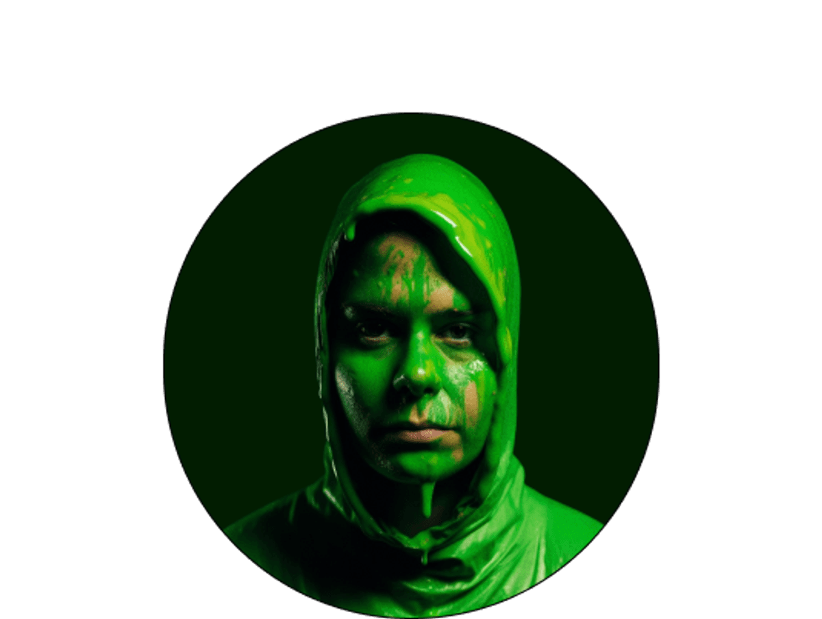 Headshot of someone covered in green paint.