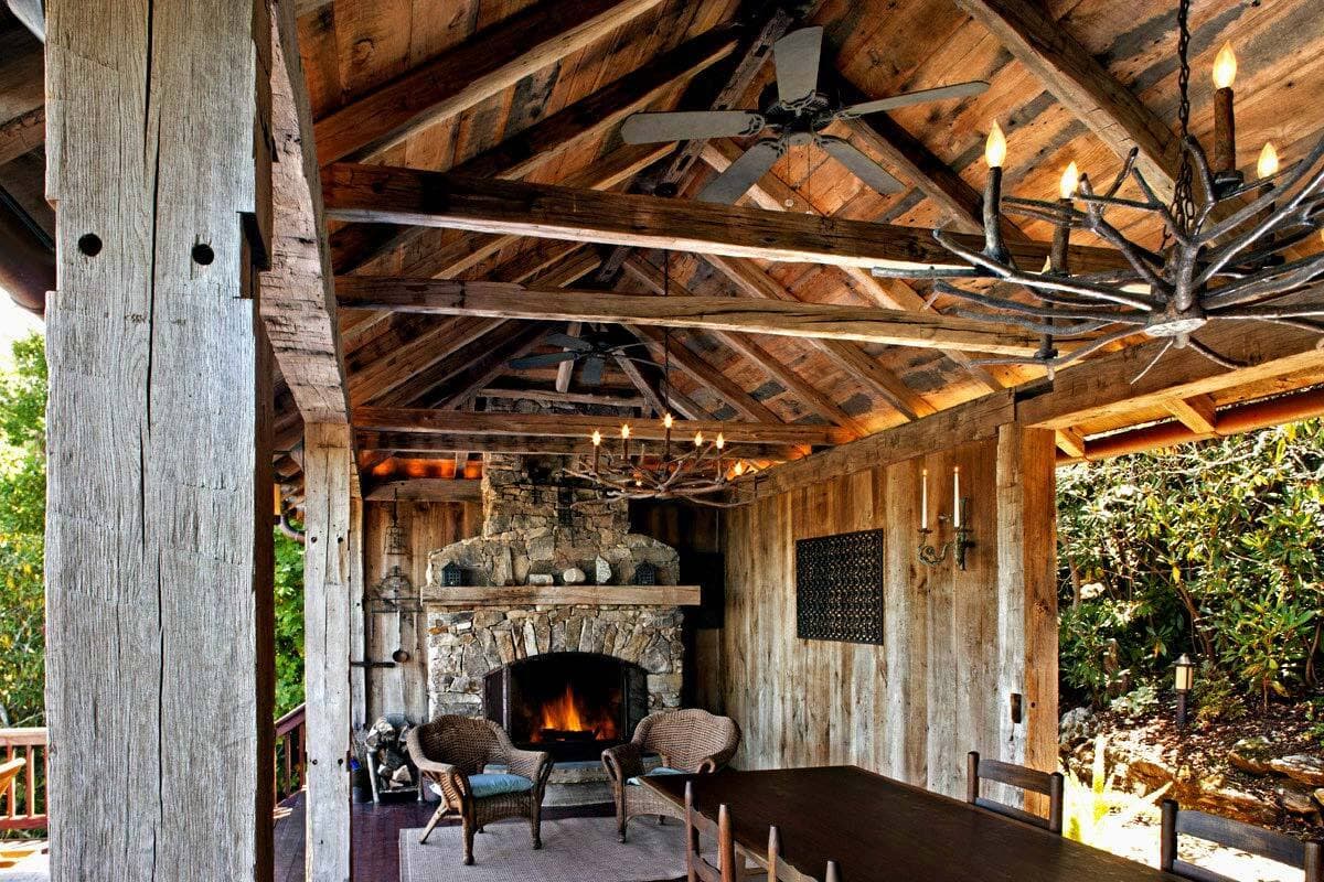 Rustic reclaimed hand hewn beams in outdoor dining room.