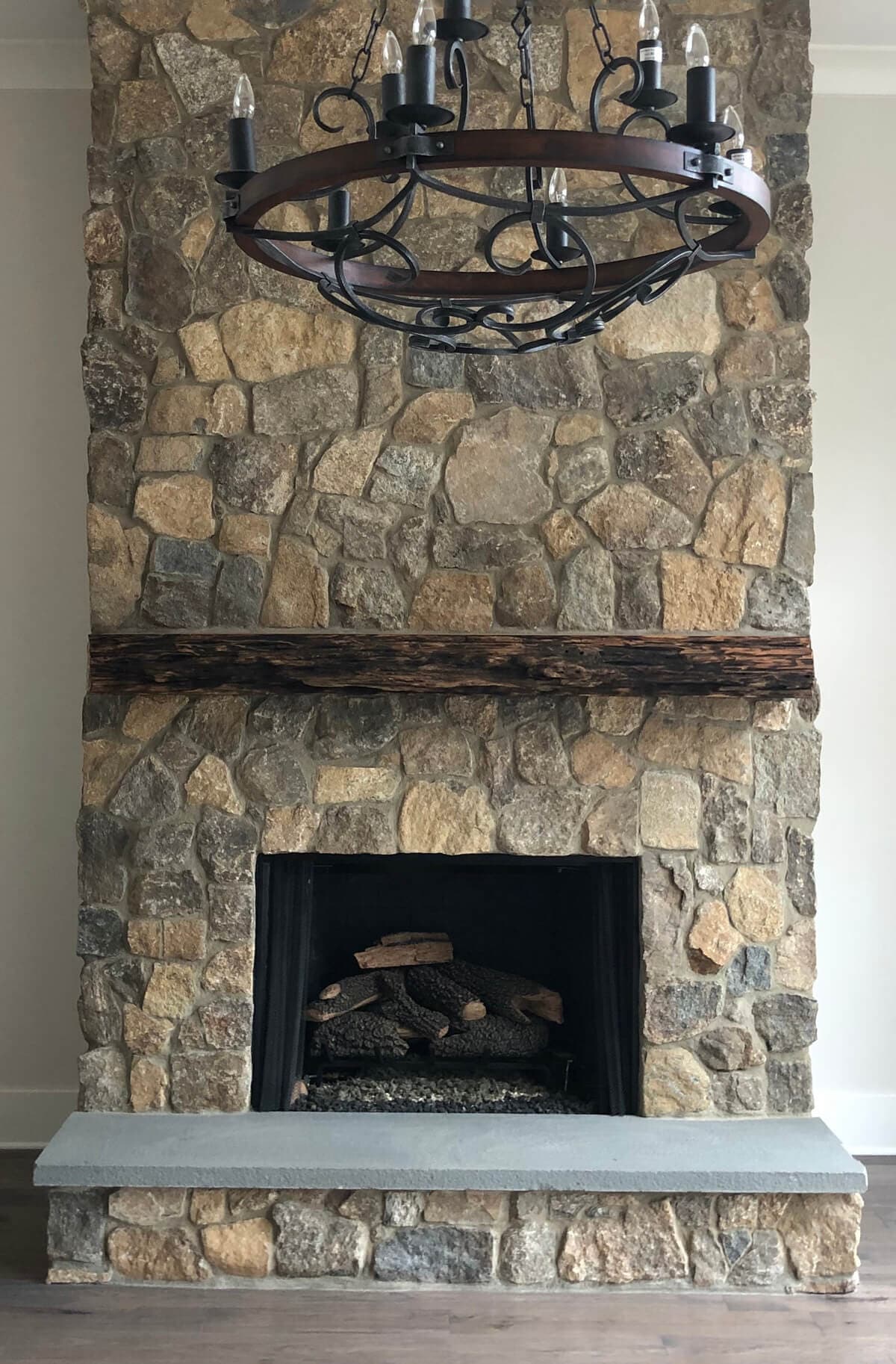 Charred heart pine wood mantel above stone fireplace in charlotte, nc