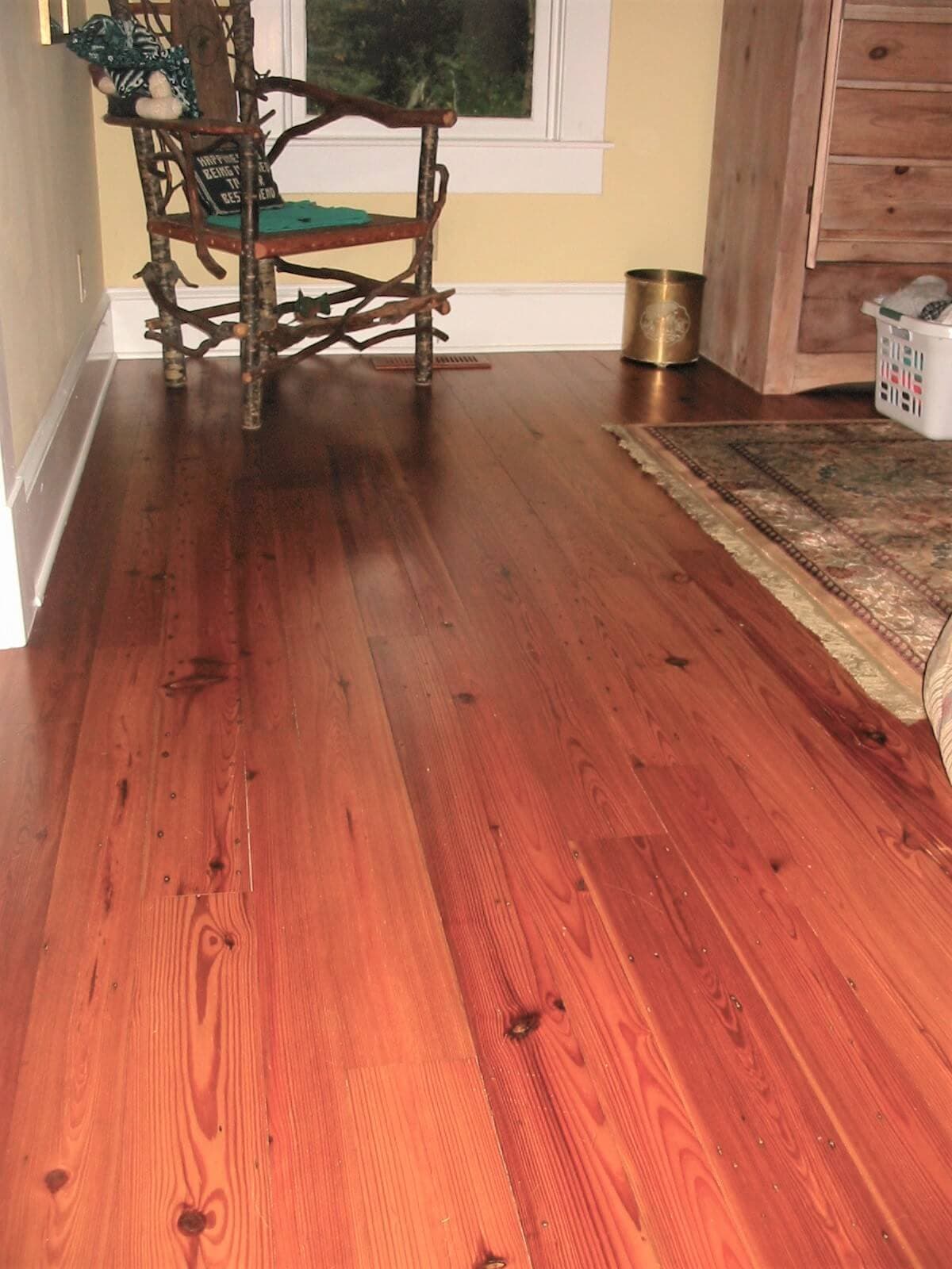 heart pine plain sawn floor near a rug and chair