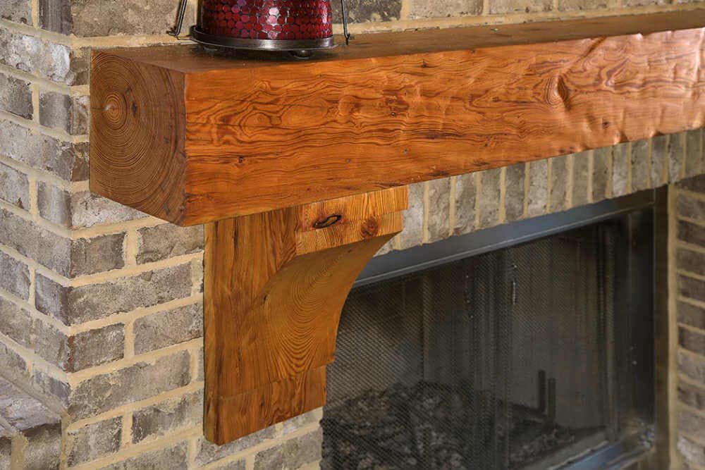 dimpled Reclaimed Heart Pine Mantel and Corbels against brick fireplace