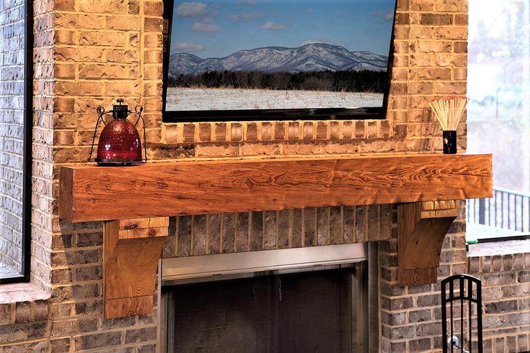 dimpled Heart Pine fireplace Mantel and Corbels under a landscape against brick