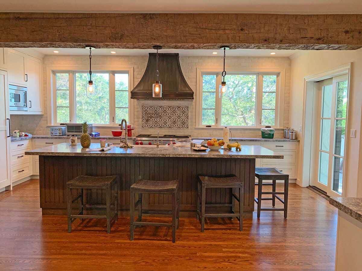 Hand hewn box beams conceal electric cords in a kitchen