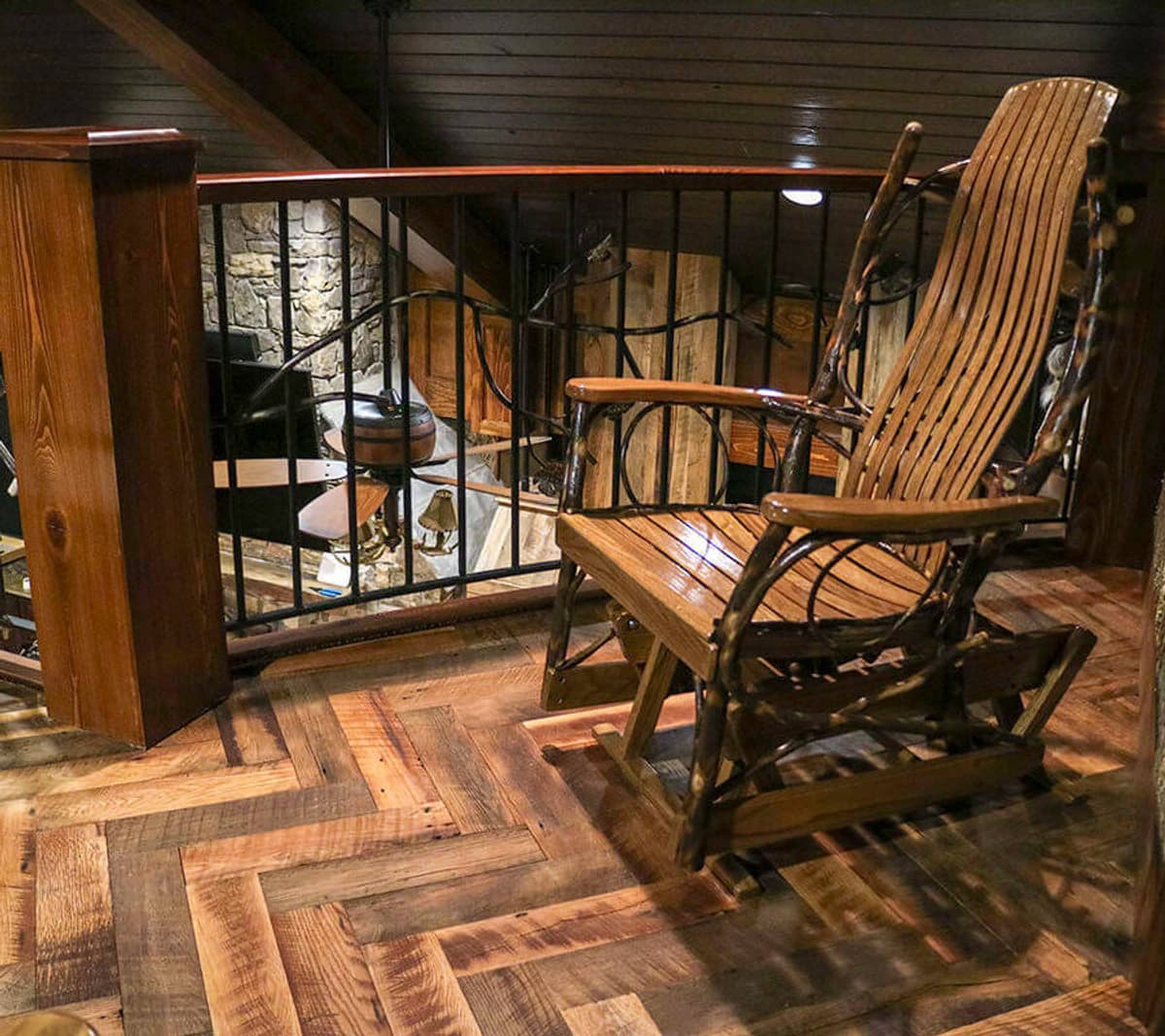 Rustic wood flooring set in herringbone pattern in mountain home loft.