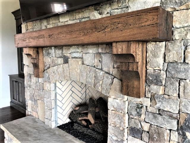 reclaimed hickory mantel and corbels over a stone fireplace