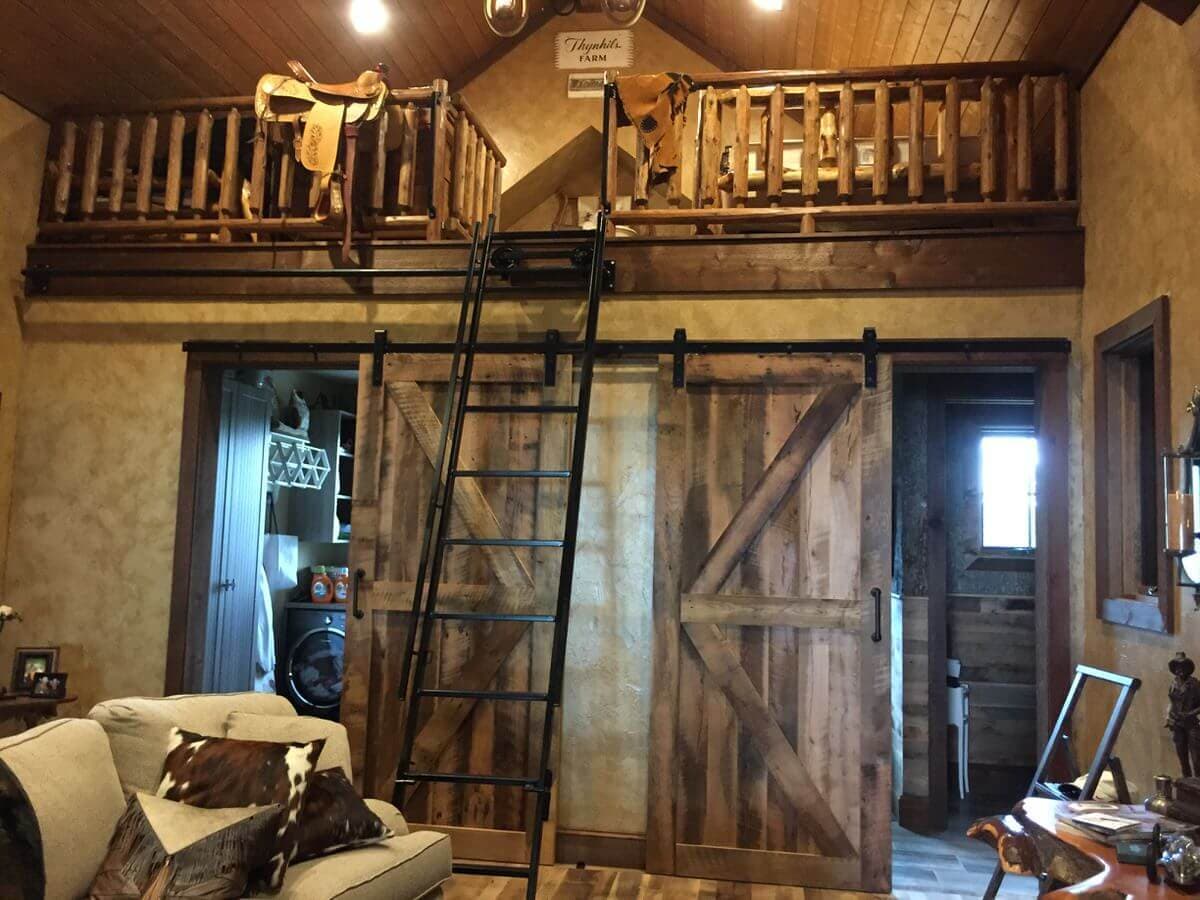 two barn doors on a sliding bar in room with a loft and cowboy details
