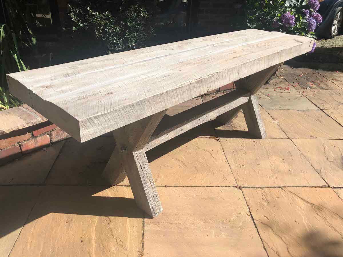 weathered gray custom reclaimed picnic table on a stone patio