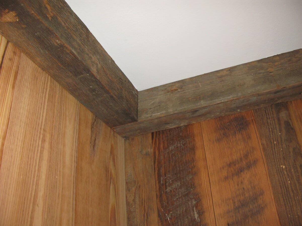 reclaimed 3 x 3 ceiling cornice beams in a corner of a reclaimed wood wall