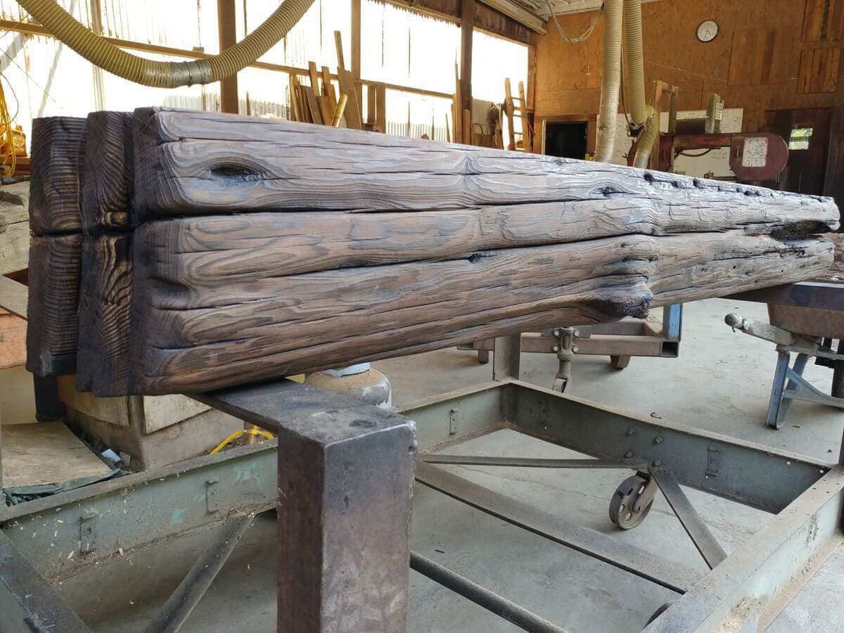 Reclaimed wood mantel undergoing preparations at Whole Log Reclaimed shop.