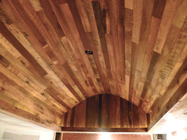 Reclaimed wood paneling on arched ceiling creates dramatic affect.