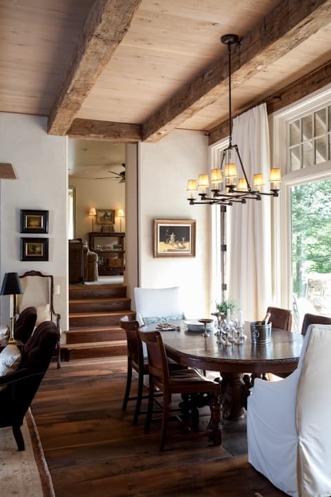 Rustic wood beam wrap above dining room.