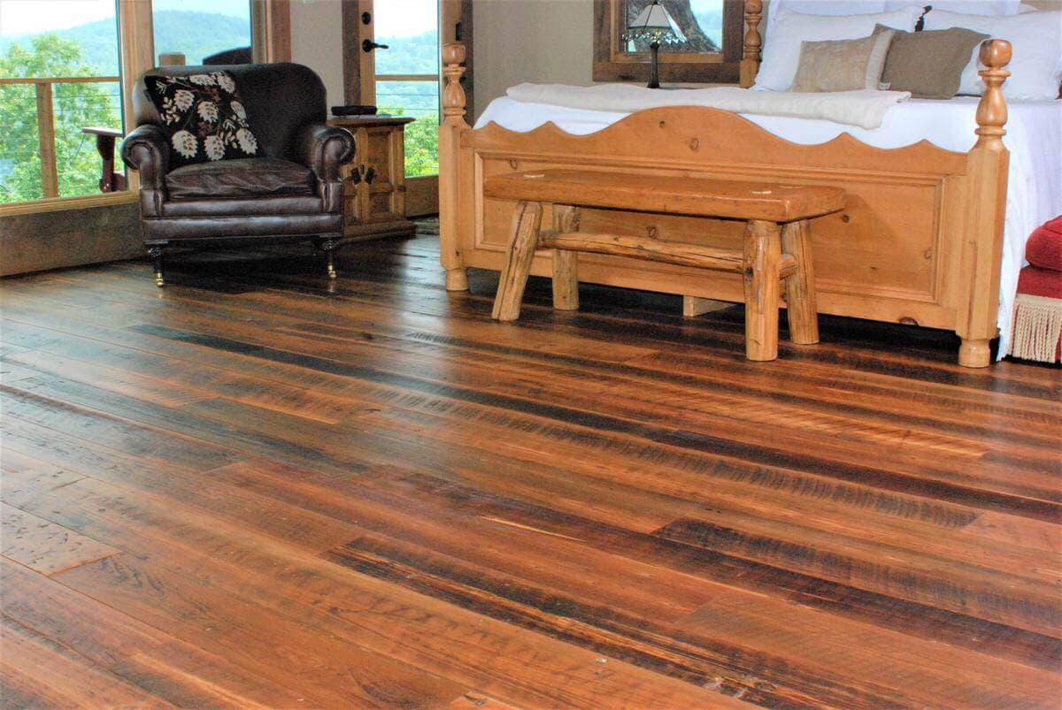 Rustic reclaimed wood flooring in master bedroom.