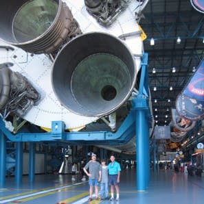 Tony standing under Saturn V booster