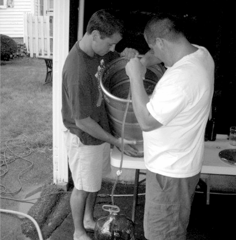 A black and white photo of co-founders Daniel and David Kleban homebrewing in their garage.