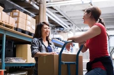 A manager and employee are working on their communication skills while talking over a production shipment.