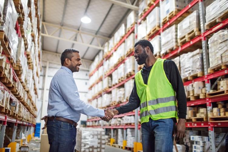 A human resource manager is shaking the hand of one of his hourly manufacturing employees