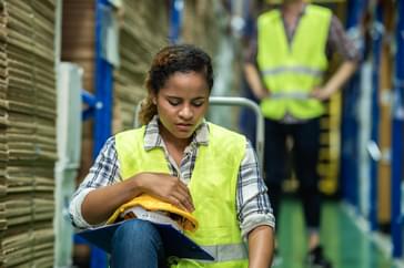 Setting Up A PTO Policy {Examples for Hourly Employees} distribution center employee holding a hard hat in her hand getting ready to take pto