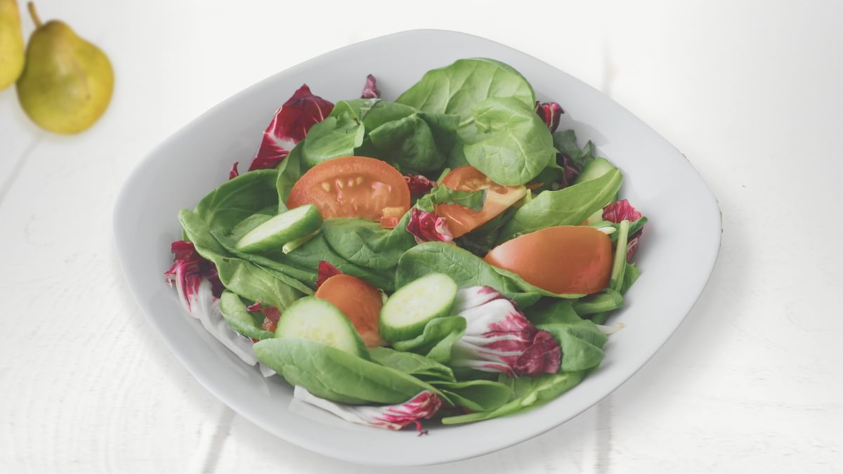 Winter leaf salad with nuts, raisins and pears with orange dressing