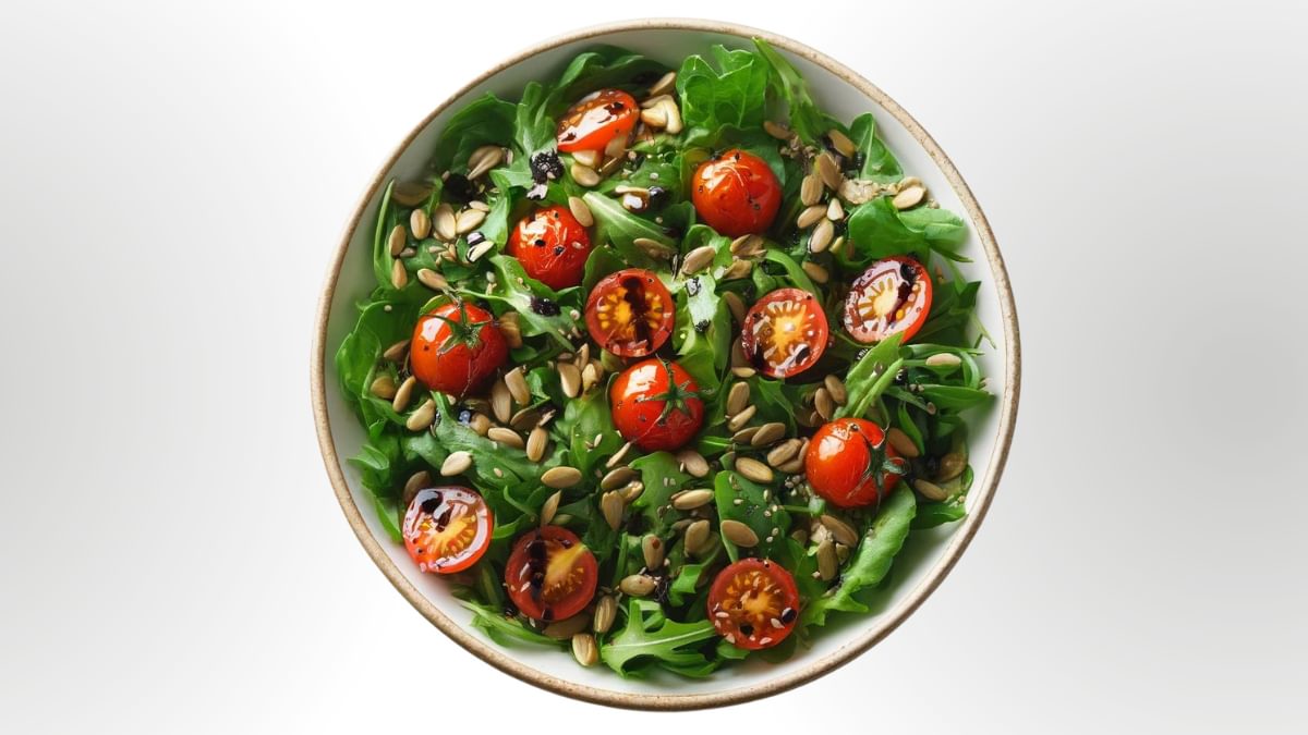 Fresh rocket salad with crunchy roasted sunflower seeds, with cherry tomatoes and balsamic dressing.