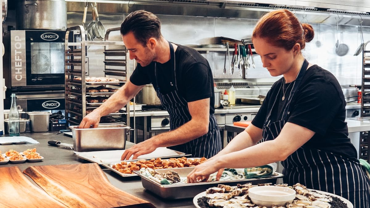 Two cooks in a kitchen cooking