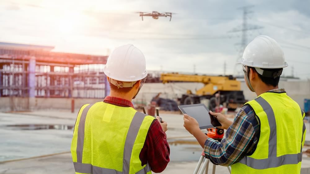 Construction workers on site flying drone